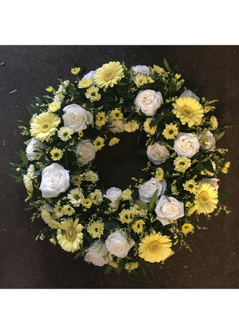 Lemon and White Funeral Wreath by Make Their Day florist. This loose wreath funeral tribute of Lemon and white flowers with focal white Roses and Lisianthus and lemon Germinis filled in with small Chrysanthemums and Limonium and seasonal foliage.