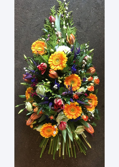 This funeral sheaf of country garden flowers and grasses is made in floral foam to prolong the life of the blooms. It is bursting with cheerful orange, purple and white flowers including Germini, Veronica, Lisianthus and other seasonal flowers and foliage.
