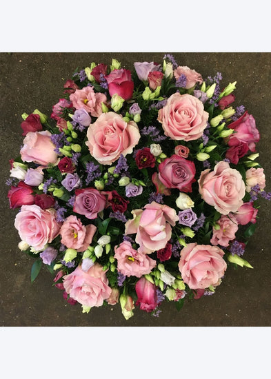 This domed funeral posy is created from pink Roses and Lisianthus interspersed with seasonal flowers and foliages.