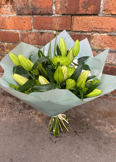 Forever keeping it classy with Make Their Day Florist.  Our men's Tesla white and green bouquet, filled with lilies simply ready to burst open accompanied by mixed foliage and apple green Chrysanthemum Blooms to very picture of class.