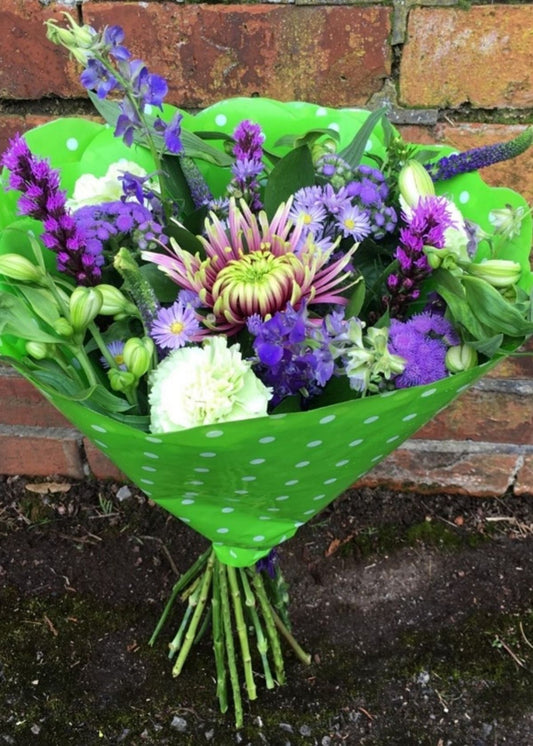 The Violet Szabo Hand Tied Bouquet is a vibrant purple Hand Tied bouquet of purple flowers including Balthazar Blooms, Purple September Flower, Ageratum, Liatris, Purple Larkspur set off with the contrasting white Alstroemeria.  A beautiful way to say how much you care on Mother's Day.