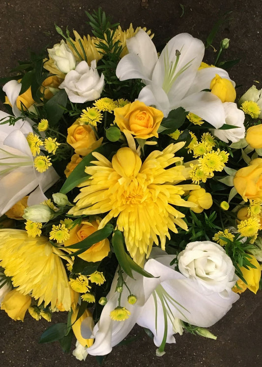 This loose, domed funeral posy is created from yellow and white seasonal flowers and foliages.