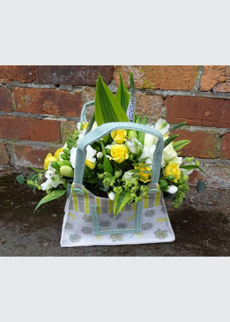 Yellowhammer Floral Bag Arrangement. This yellow and white arrangement is made up of spray Roses, Lisianthus, Veronica, Freesia, Carnations and seasonal flowers and foliages. A gorgeous gift for a new Mum or Get Well Soon.